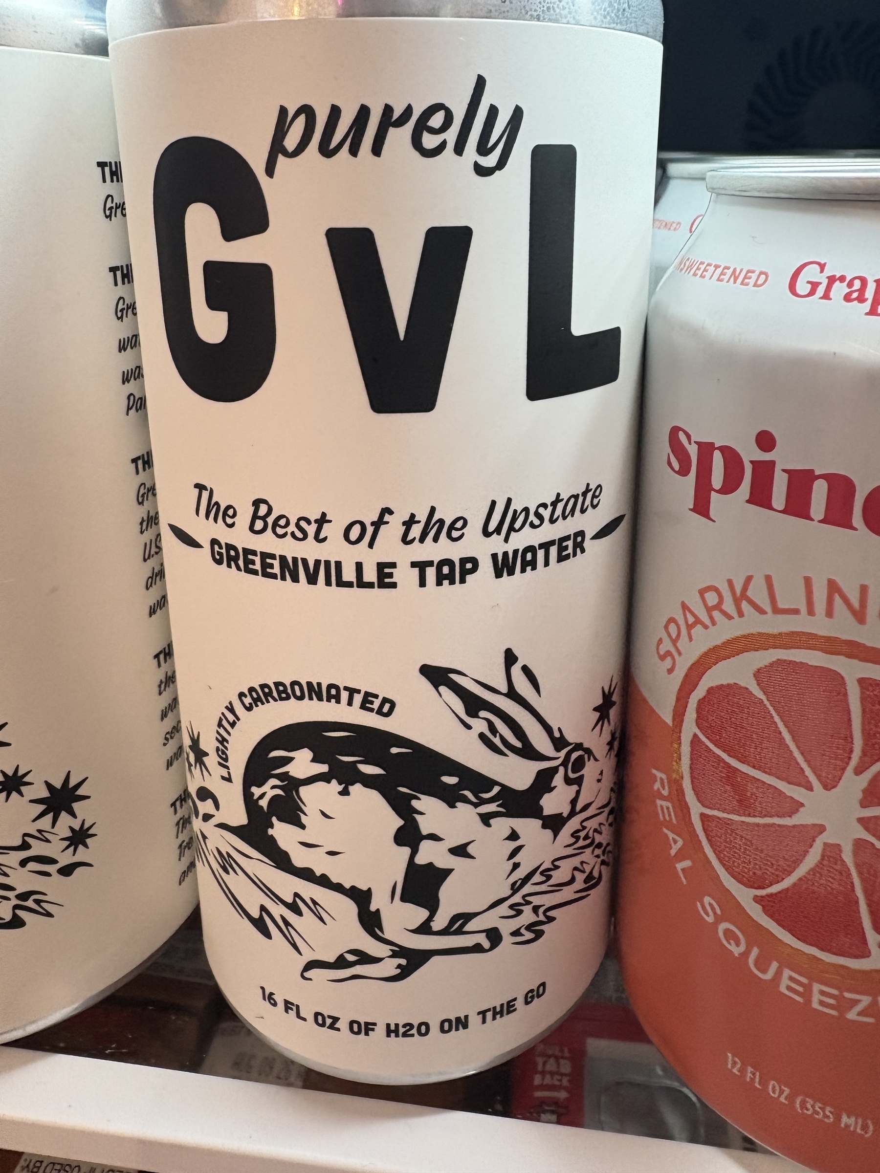 A 16 ounce can of “purely GVL” which is lightly carbonated Greenville tap water. The label is white with black text and an illustration of a rabbit.